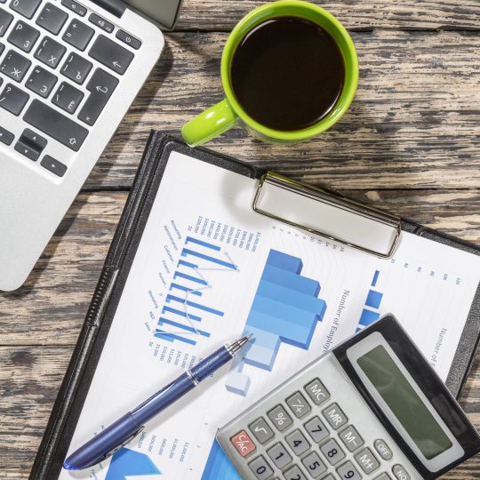 laptop-coffee-cup-document-with-diagrams-pen-calculator-office-table-flat-lay_488220-22263